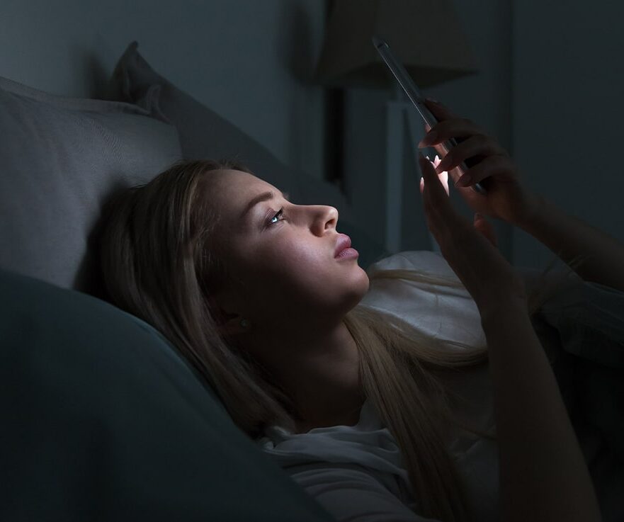 girl holding the mobilephone in dark room